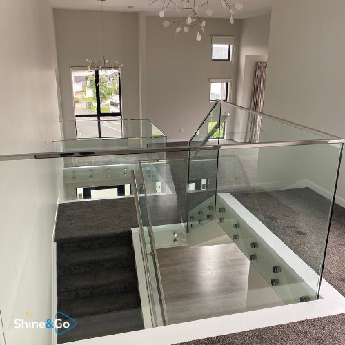 Stairwell landing with glass balustrade and skylight, cleaned by Shine&Go NZ
