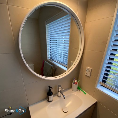Bathroom with round mirror cleaned by Shine&Go NZ